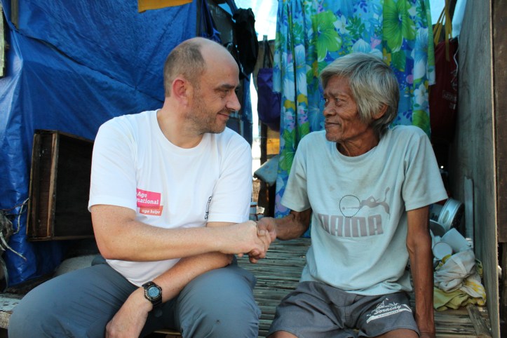 Toby Porter, Chief Executive of HelpAge International shakes hands with a villager in the Philippines © Joselito Dela Cruz HelpAge International